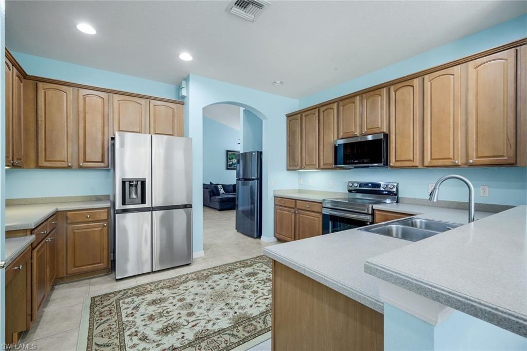Kitchen featuring light wood-finish cabinetry, stainless steel appliances, and light-toned countertops