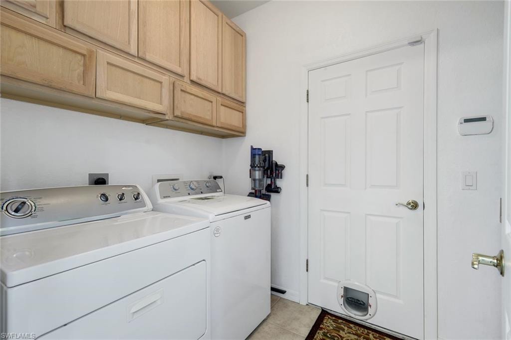 Laundry room featuring overhead wood-finish cabinetry, white appliances, and a white paneled door