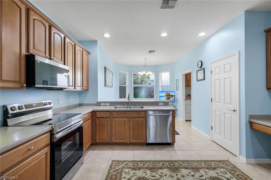Kitchen featuring wood cabinetry, stainless steel appliances, recessed lighting, and a bay window
