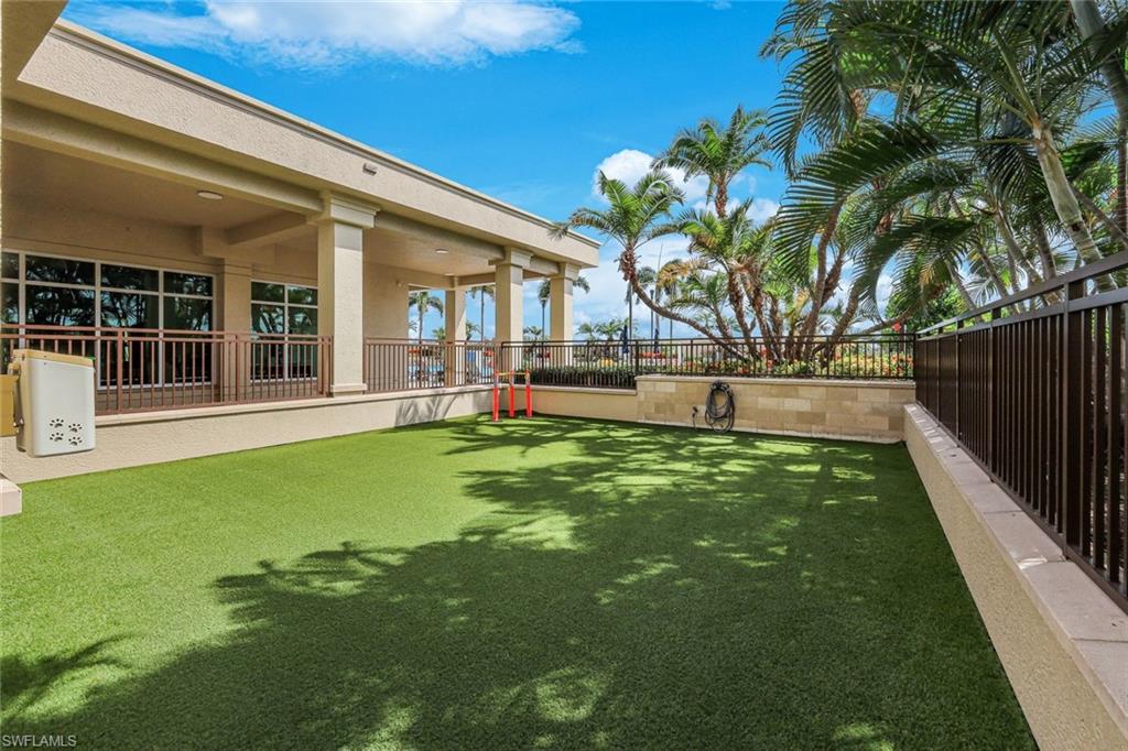 Expansive artificial turf area featuring a columned covered patio