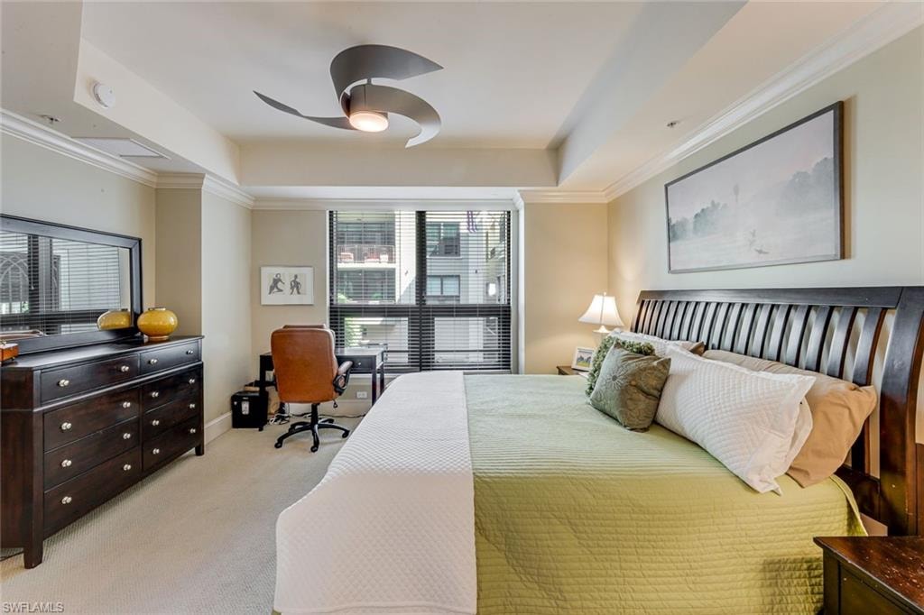 Carpeted room featuring a ceiling fan with integrated lighting, a large window with horizontal blinds, and crown molding