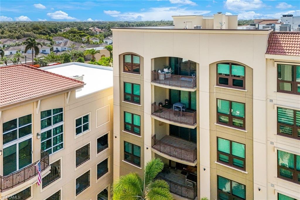Multi-story building featuring stacked balconies with decorative railings and arched structural accents