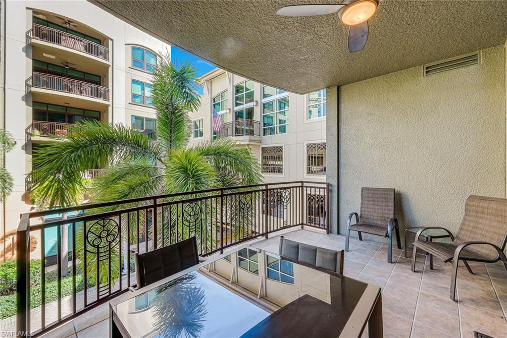 Covered outdoor balcony featuring tile flooring and a decorative metal railing