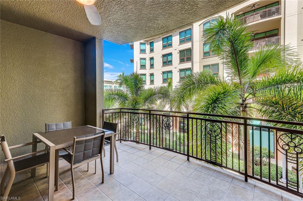 Curved balcony featuring light-colored tile flooring and a decorative black metal railing