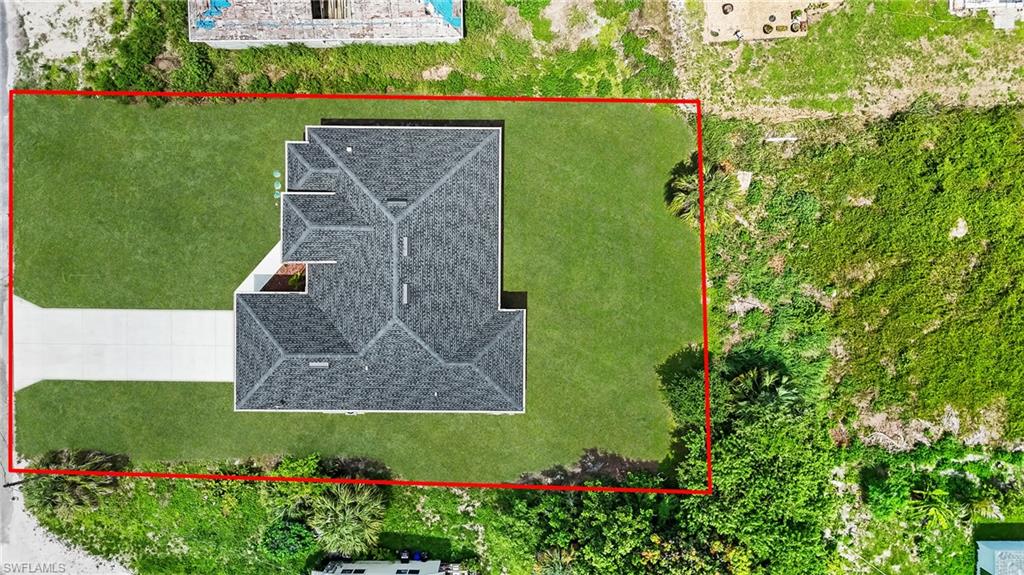 Aerial perspective showcasing a single-story residence with a gray shingle roof and a concrete driveway