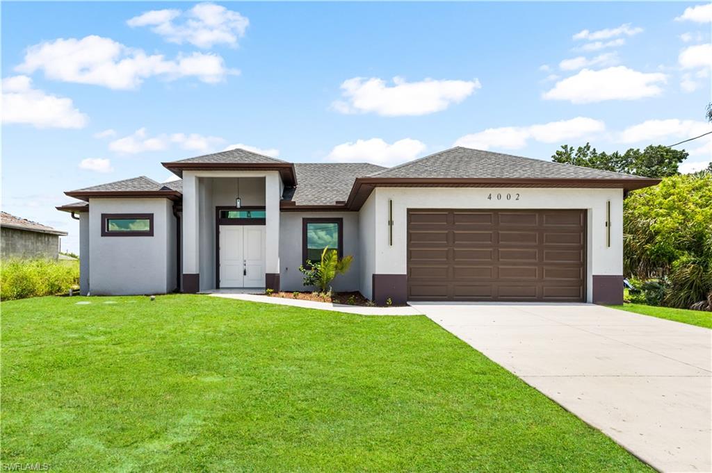 Contemporary stucco exterior with a prominent double-door entry, a two-car garage, and a concrete driveway