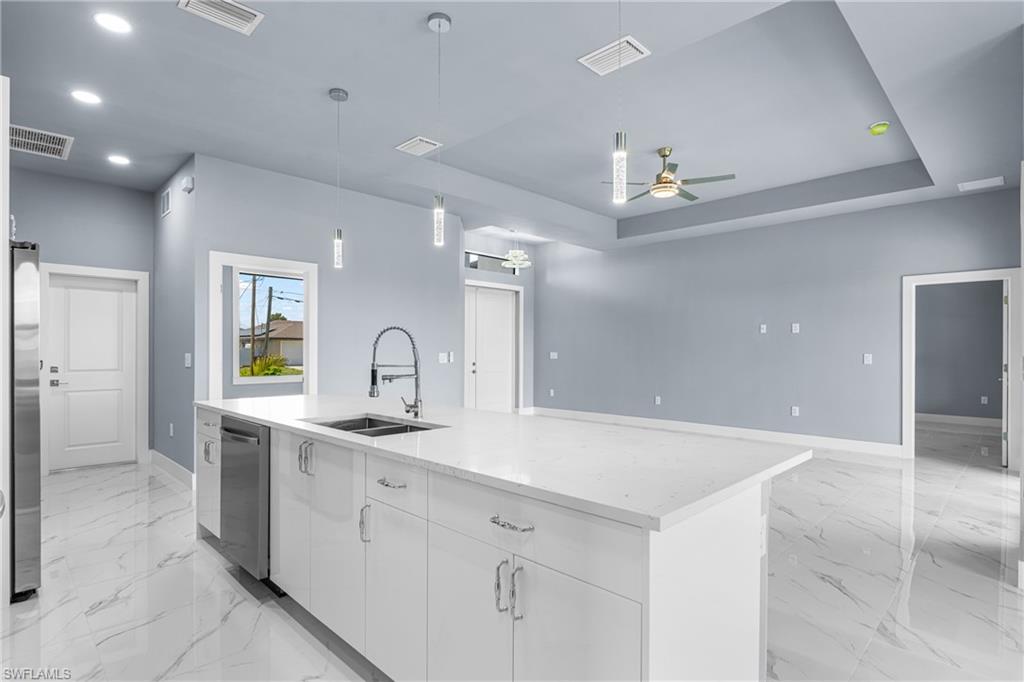 Spacious kitchen island featuring a dual basin sink and stainless steel dishwasher