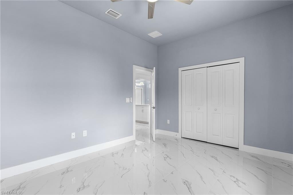 Spacious interior featuring tile flooring, light-toned walls, white baseboards, a ceiling fan, and bi-fold closet doors