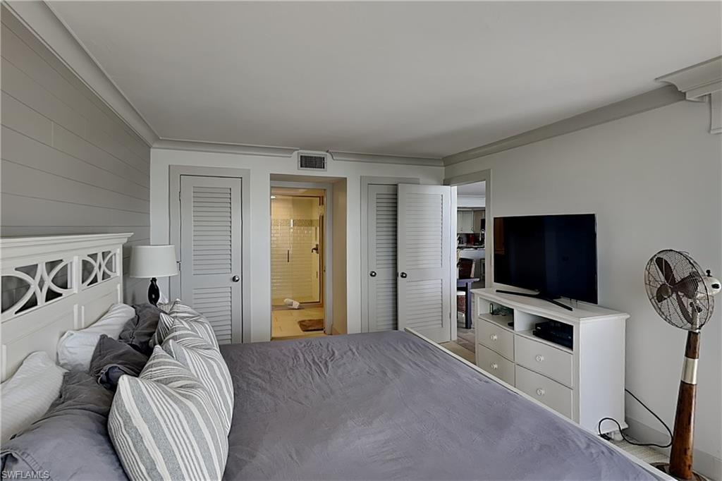 Bedroom featuring a decorative headboard and shiplap accent wall