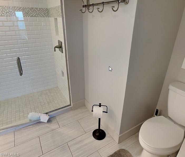 Glass-enclosed shower with subway tile surround, mosaic tile accent, recessed shelving, and a bronze-finish shower fixture