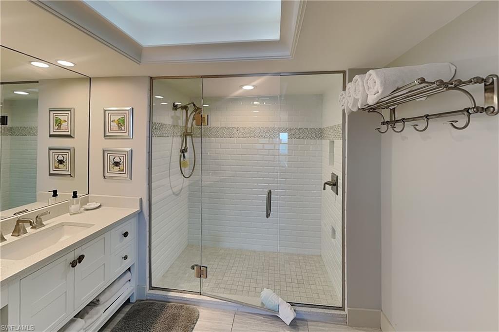 Walk-in shower with clear glass enclosure and white subway tile surround