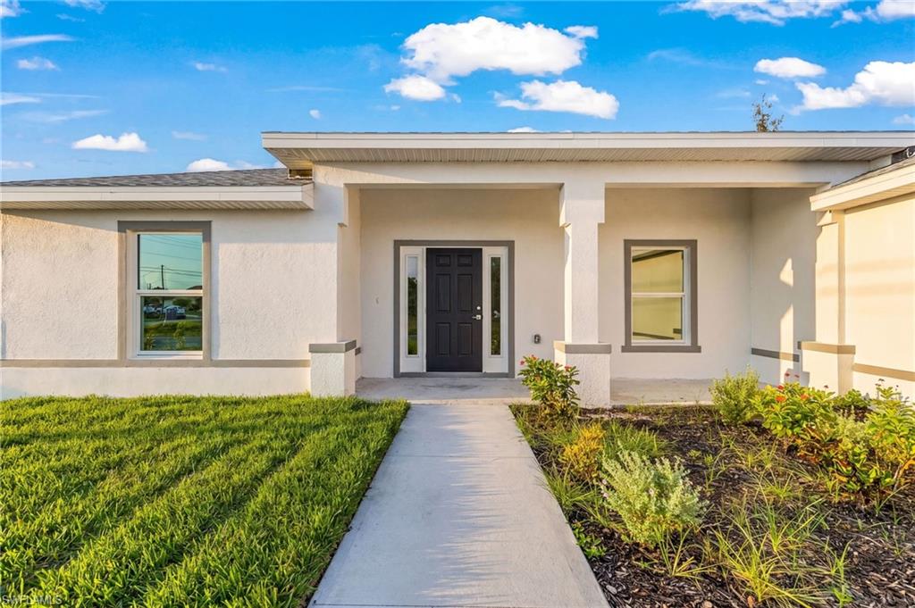 Contemporary facade with a covered entry, dark entry door, and trim detailing