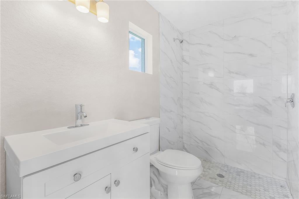 Bathroom featuring a white vanity with integrated sink, chrome faucet, and overhead light fixture
