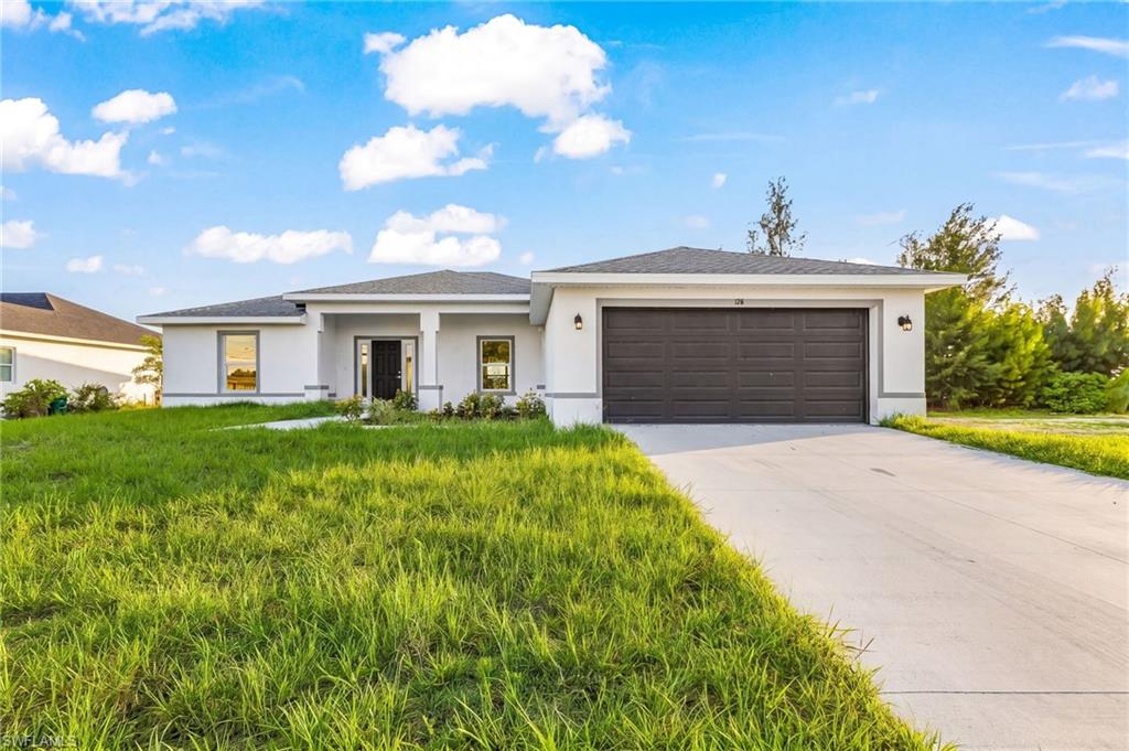 Single-story residence featuring a gray asphalt shingle roof and a concrete driveway