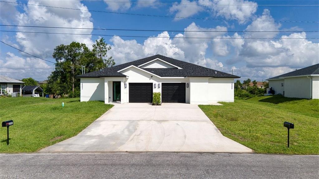 Contemporary duplex featuring a white stucco exterior, black garage doors, and a dark shingle roof