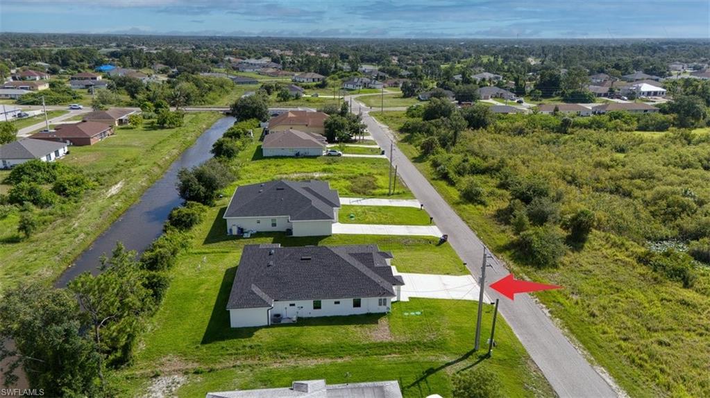 Expansive property parcel featuring a paved road frontage, established power poles, and a clear, flat topography