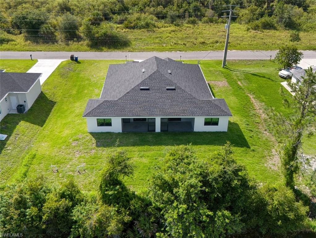 Newly constructed residence featuring a dark shingle roof and white exterior