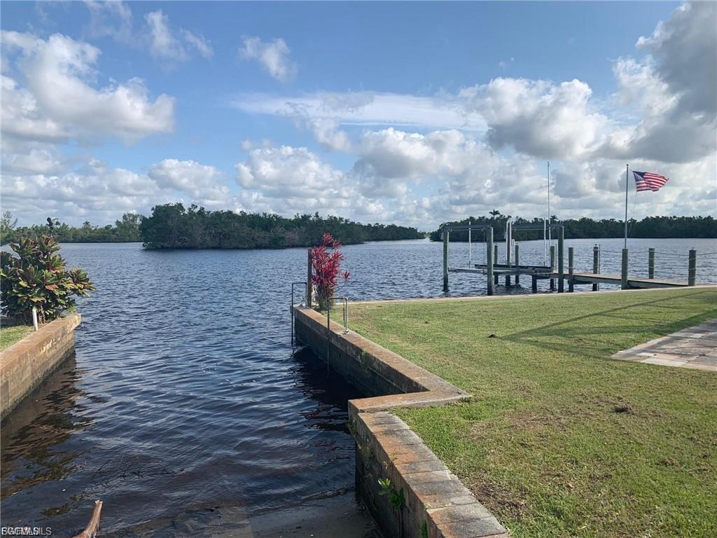Waterfront property featuring a private boat slip, an additional dock, and a manicured lawn