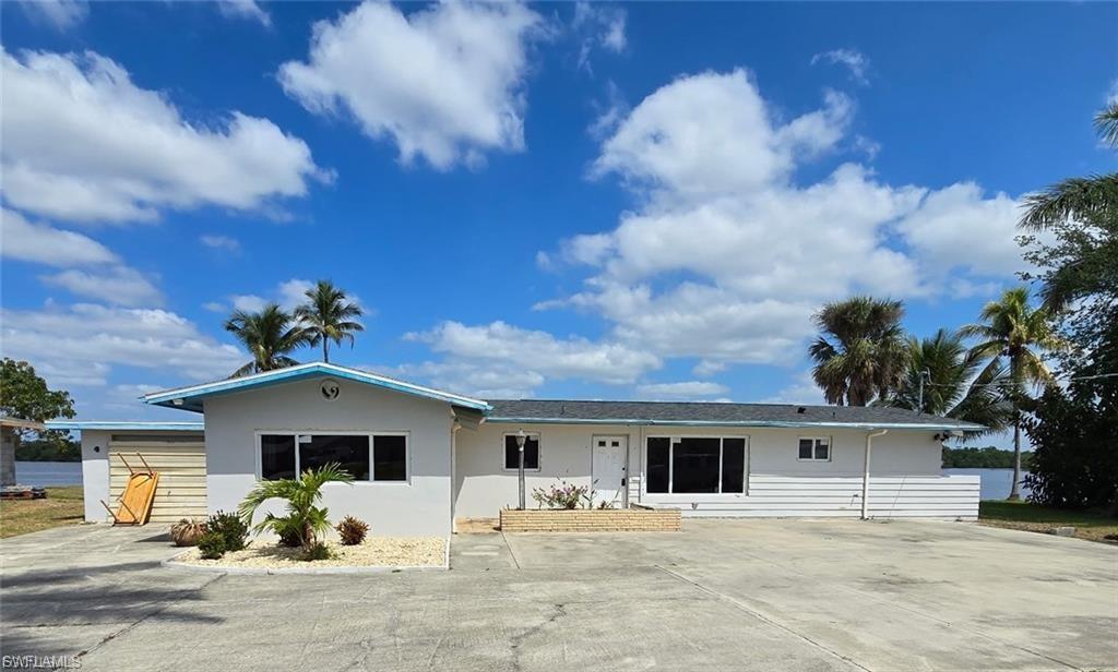 White exterior residence featuring a black shingle roof and contrasting light blue trim