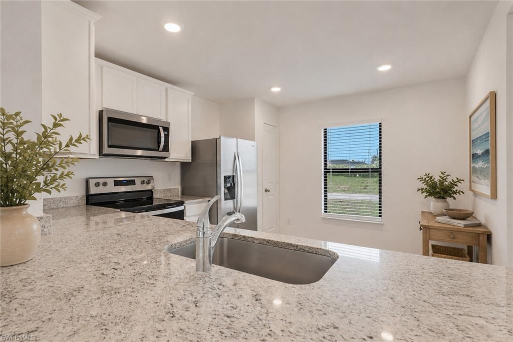 VOpen Kitchen with granite counter tops, white cabinets, very open and room for a table.Virtually staged