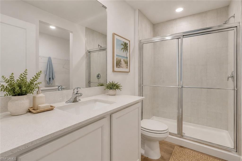 Primary bath with walk in shower and quartz counter tops and matching vanities. Virtually staged