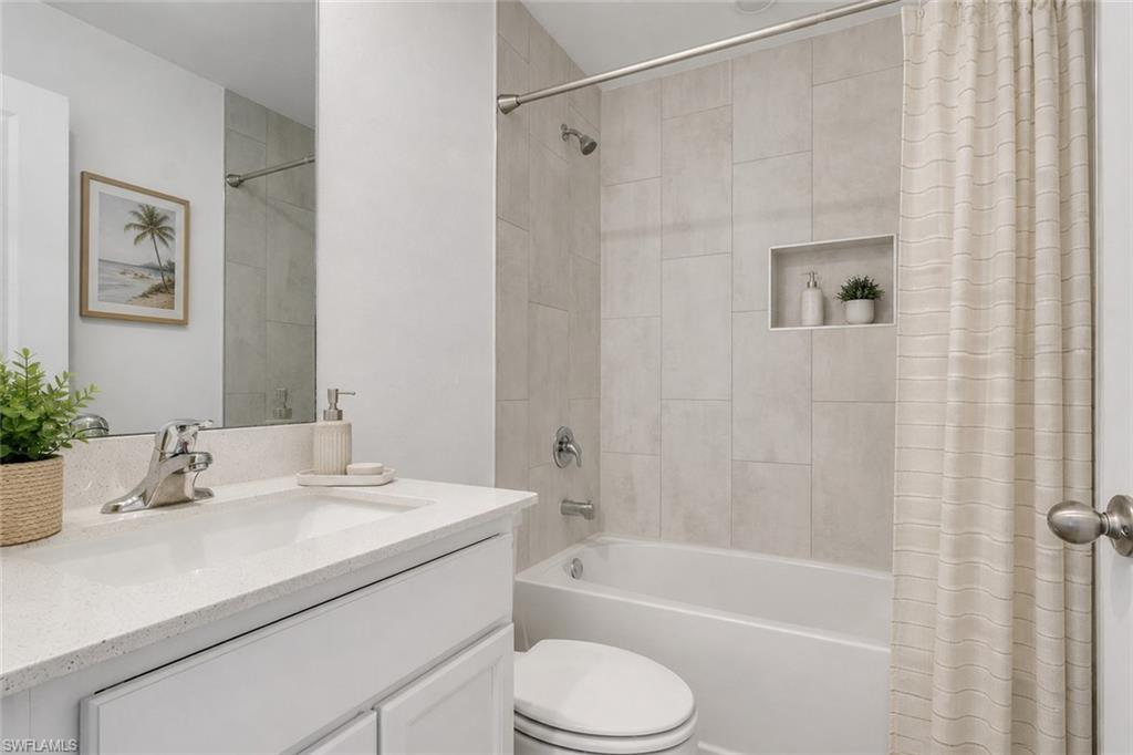 Guest bath with combo tub/shower and quartz counter tops and matching vanities. Virtually staged