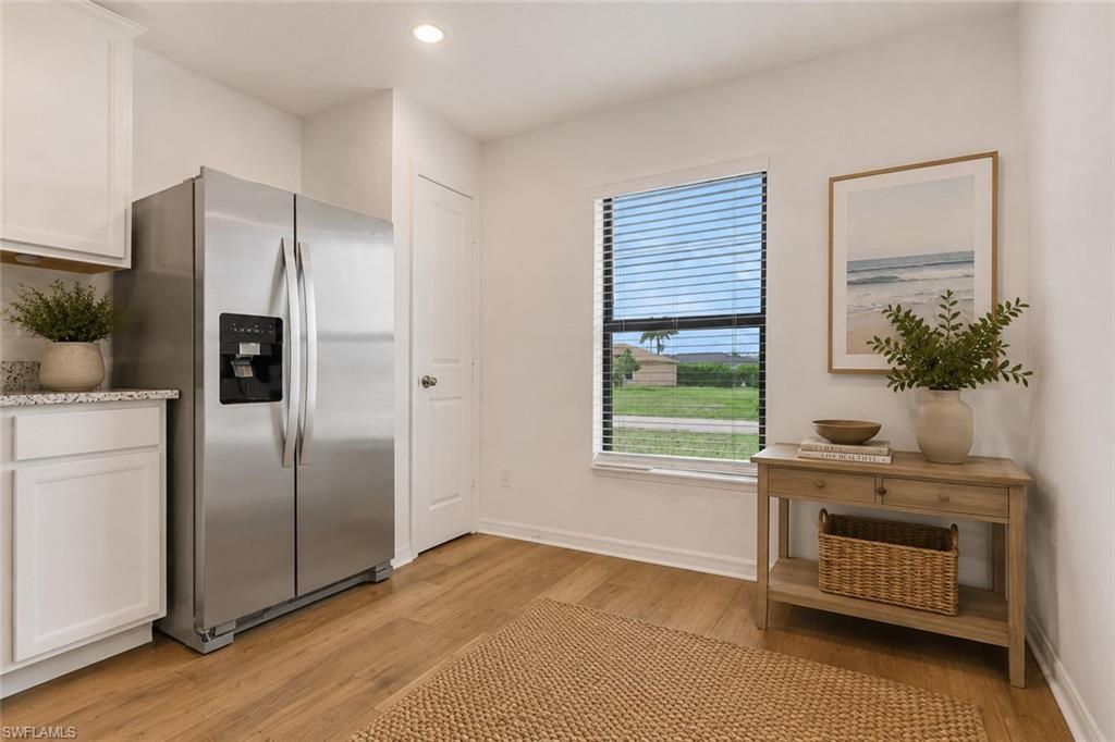 Open Kitchen with granite counter tops, white cabinets, very open and room for a table. Virtually staged