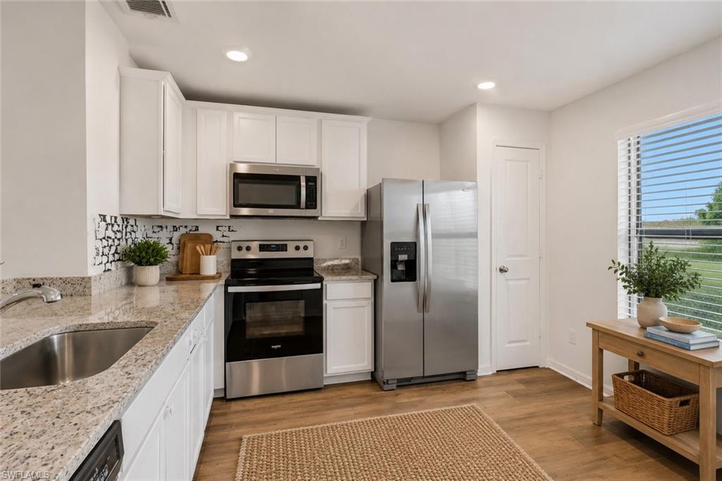 Open Kitchen with granite counter tops, white cabinets, very open and room for a table. Virtually staged