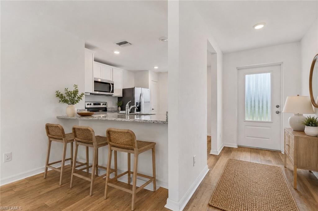 Breakfast bar looking into the kitchen with granite counter top.  Virtually staged