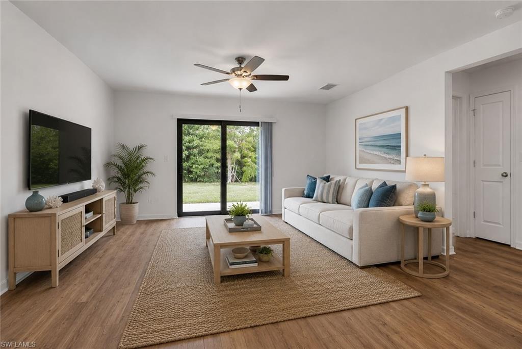 Great room with LVF flooring and impact sliding glass doors to the lanai. Staged