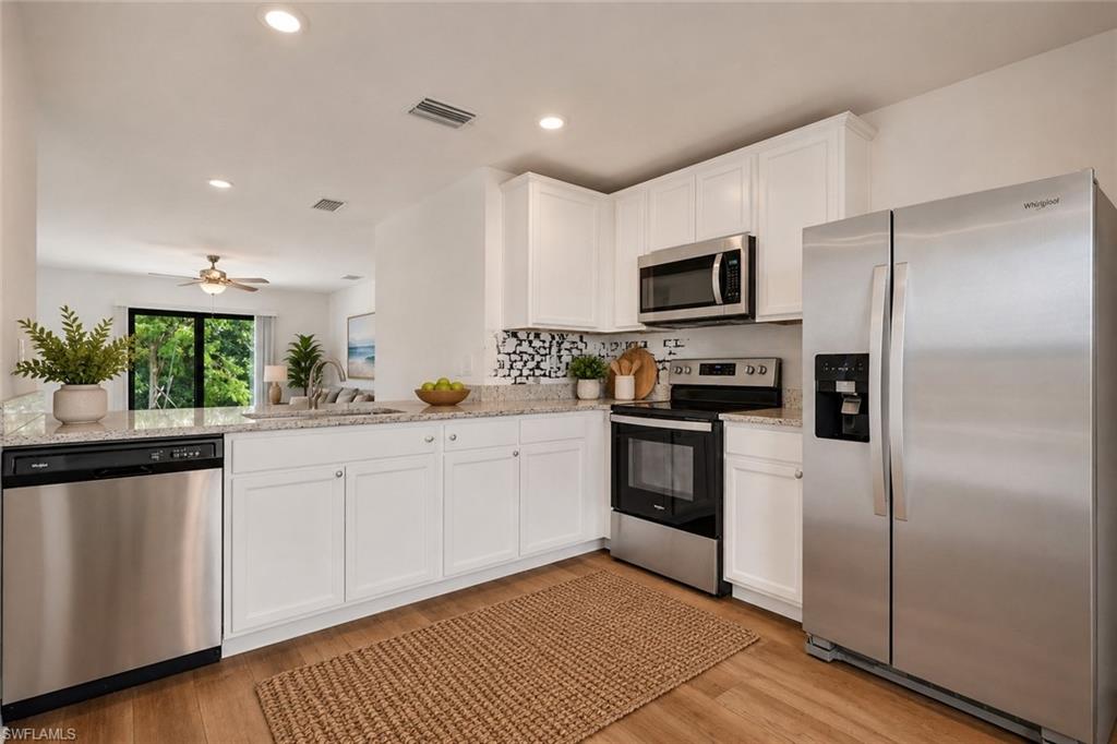 Open Kitchen with granite counter tops, white cabinets, very open and room for a table. Virtually staged