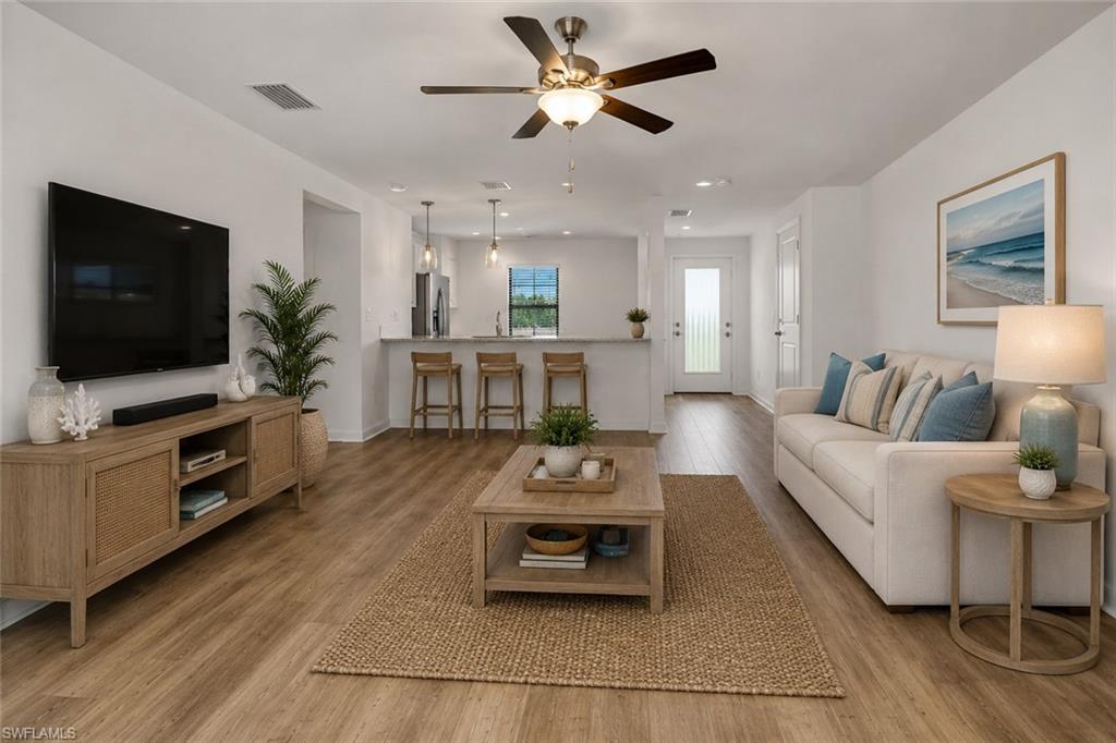 Great room with LVF flooring and impact sliding glass doors to the lanai.  Virtually staged