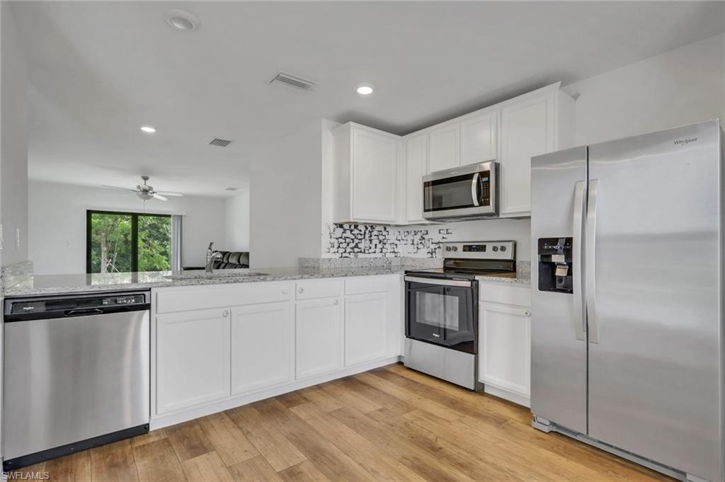 Open Kitchen with granite counter tops, white cabinets, very open and room for a table.