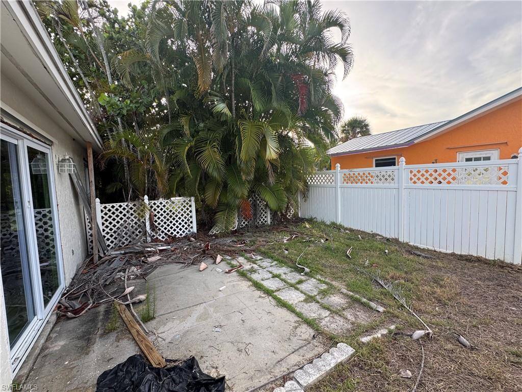 Concrete patio area with a white privacy fence