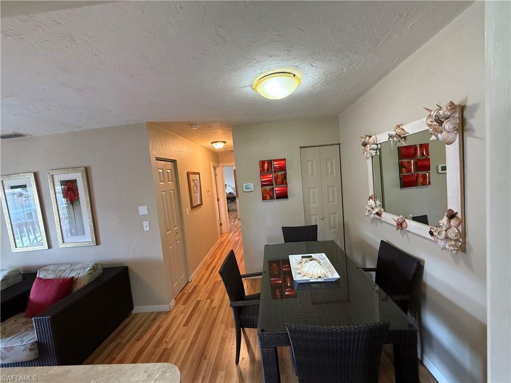 Dining area featuring wood-finish flooring, a contemporary ceiling light fixture, and a neutral wall color