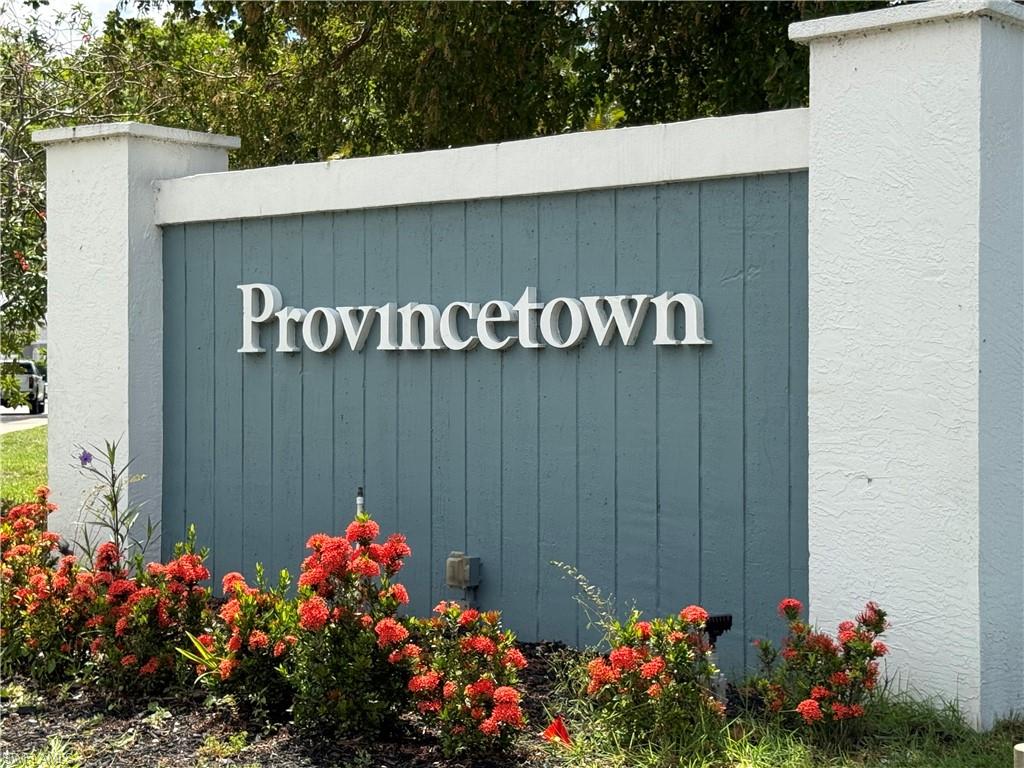 Provincetown entry sign featuring white dimensional lettering, a vertical plank backer in a muted blue hue, and stucco-finished columns