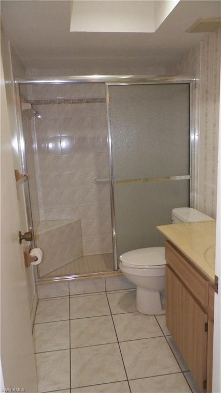Bathroom featuring a shower with sliding glass doors, a built-in shower bench, and full tile surround