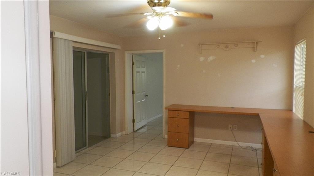 Tiled flooring throughout with a built-in wood-finish L-shaped desk