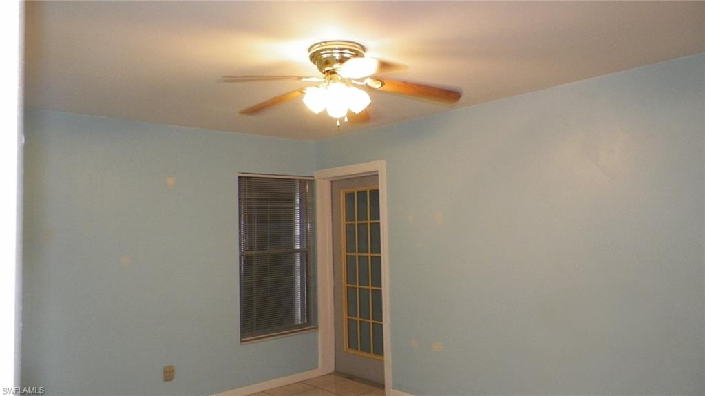 Ceiling fan with light fixture, window with blinds, and a glass-paneled door