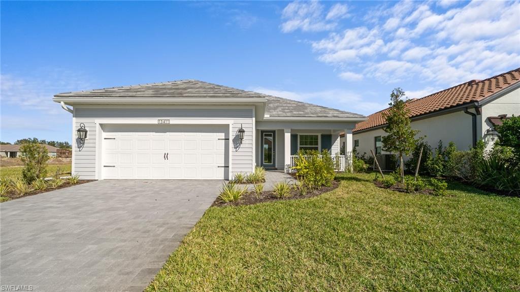 Single-story residence featuring light gray siding, a covered front porch, and a two-car garage with decorative hardware