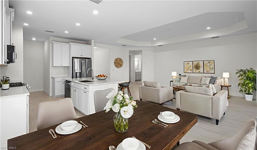 Where gathering comes naturally. The thoughtfully designed floor plan connects the kitchen, dining area, and great room into one expansive living space. Recessed ceilings, upgraded wood-look tile flooring, and neutral finishes create a sophisticated backdrop ready for your personal style while maintaining the home's bright, airy feel.