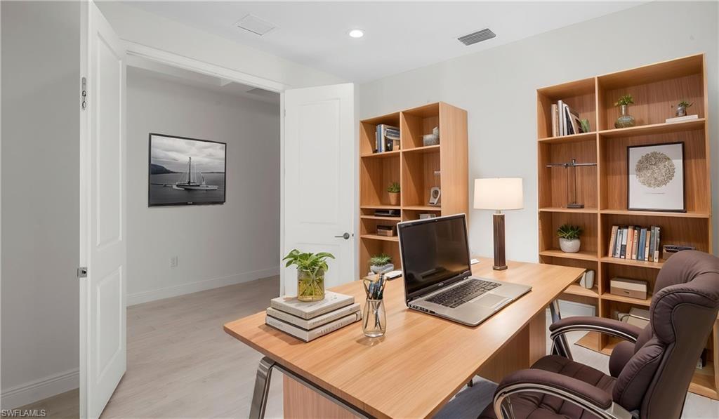 Dedicated room with light wood-finish flooring and white walls