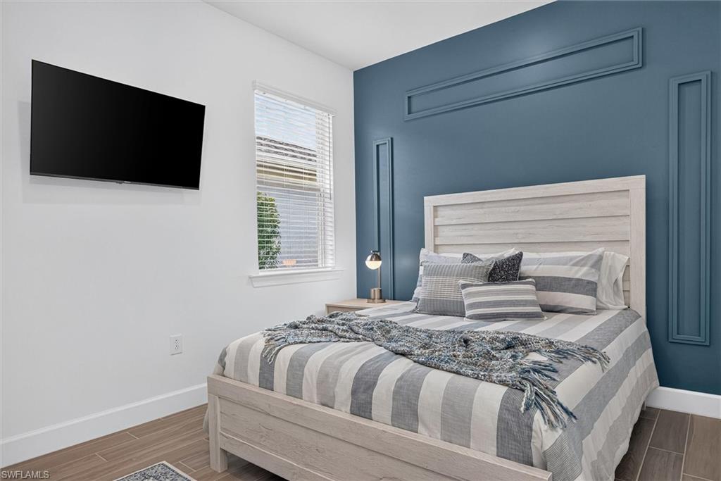 Light and bright 2nd bedroom with accent wall and TV