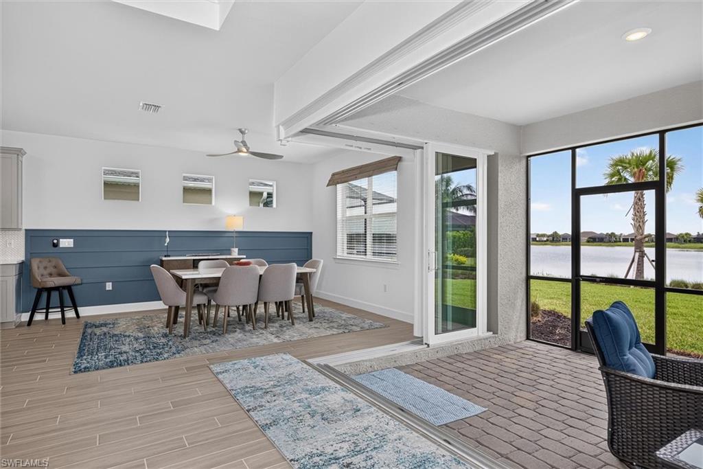 Dining area features corner sliders that open completely to the screened lanai, creating seamless indoor-outdoor living