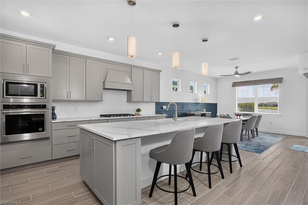 Chef-inspired kitchen featuring quartz countertops, designer lights and built in appliances