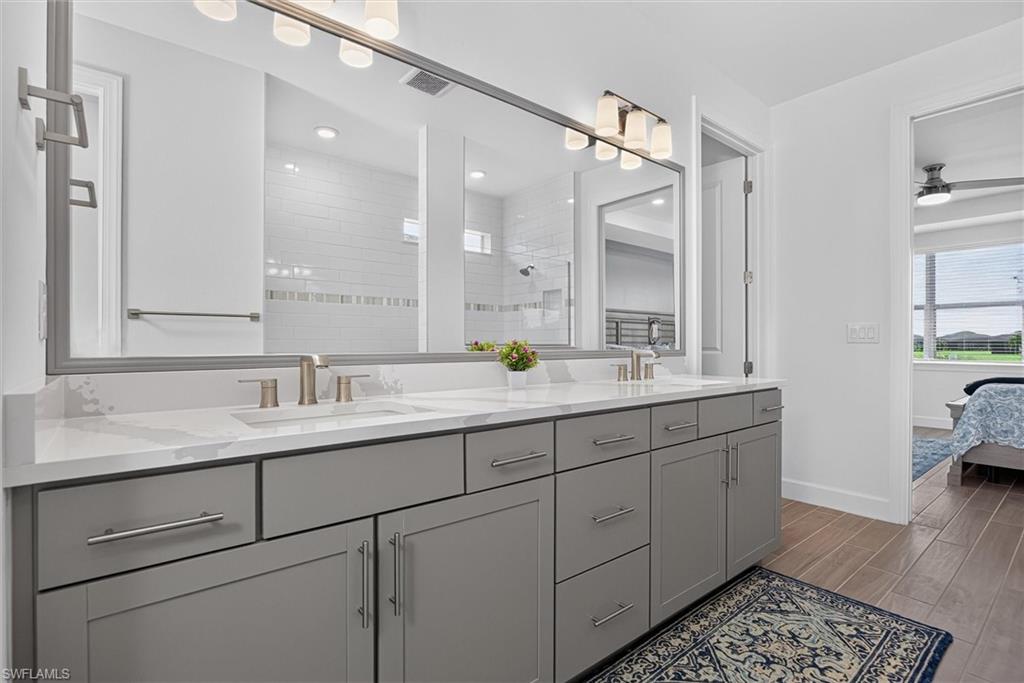 Luxurious primary bath with dual vanities, quartz countertops and abundant storage