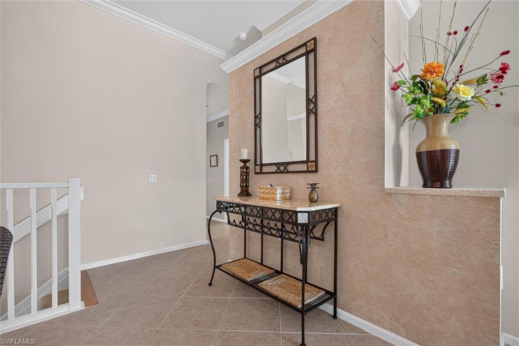 Entryway featuring neutral wall finishes and crown molding