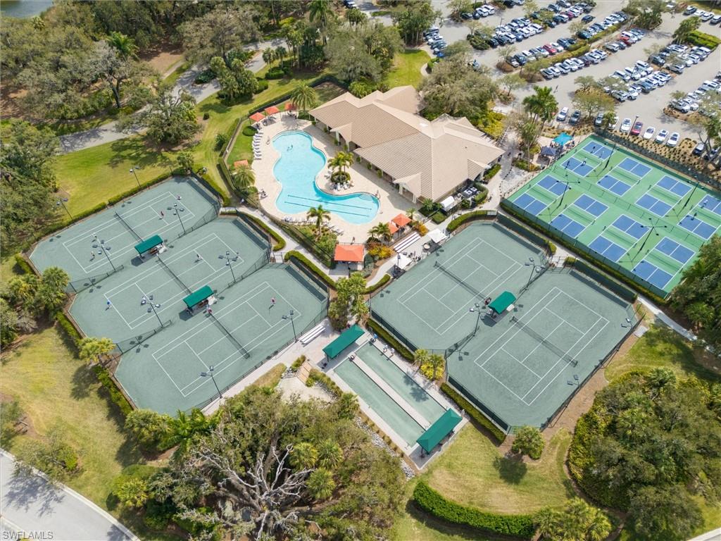 Expansive recreational area featuring multiple tennis courts, pickleball courts, a large swimming pool, and a dedicated clubhouse
