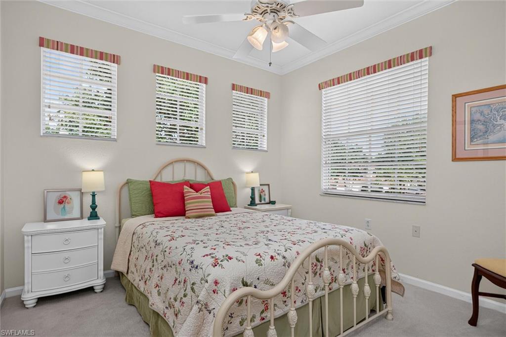 Bedroom featuring a ceiling fan with light fixture, three windows with horizontal blinds and valances, and light-toned wall paint