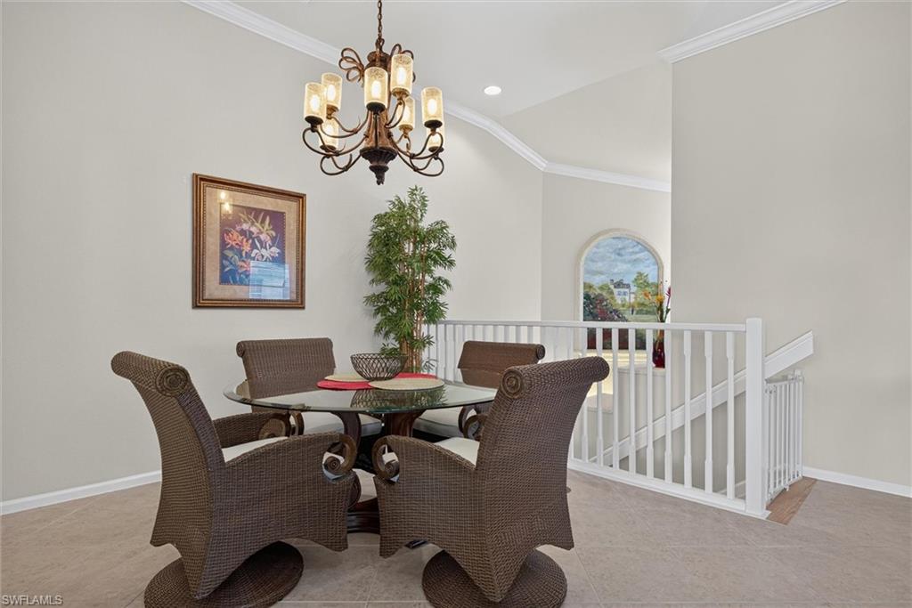 Open-concept dining area featuring a vaulted ceiling and a decorative chandelier